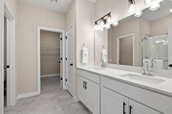 a bathroom with two sinks and a mirror and a shower